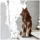 Ein brauner Hund mit einem flauschigen Fell sitzt auf einer weißen Treppe, trägt eine grüne Lederleine mit einem goldenen Clip und schaut zur Seite.