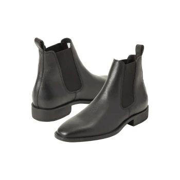 Ein Paar elegante schwarze Chelsea-Stiefel aus Leder mit elastischen Seitenpaneelen, die eine spitze Zehe und einen niedrigen Absatz zeigen.