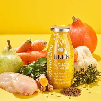 Eine SmoothieDog-Hühnchen-Snackflasche umgeben von Karotten, Birne, Kürbis und Hühnchen, mit Text, der natürliche, getreidefreie Zutaten hervorhebt.