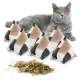 Eine graue Katze mit leuchtend orangefarbenen Augen liegt neben sechs dreieckigen Katzenminzkissen in beige, weiß und schwarz, mit getrockneter Katzenminze, die davor verstreut ist.