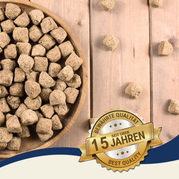 Schüssel mit braunen Haustierfutterpellets auf Holzuntergrund mit goldenem Abzeichen „15 Jahren Best Quality“ auf Deutsch.