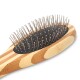 Nahaufnahme einer Holz-Haustierpflegebürste mit Metallborsten und einem schwarzen Gummibasis, die ihr ergonomisches Design zeigt.