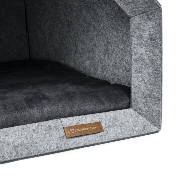 Graues Haustierbett mit einem weichen schwarzen Kissen innen, mit einem Lederetikett, das "rexproduct.com" liest.