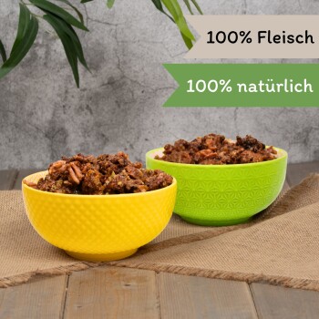 Nahaufnahme einer Dose Haustierfutter mit fleischiger Textur und Etiketten: getreidefrei, hoher Proteingehalt, kein Zuckerzusatz, Vitamine A, E und D3.