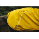 Nahaufnahme eines gelben RUFFWEAR Hunderegenmantels, der sein wasserdichtes Design mit Wassertropfen auf dem Stoff zeigt.