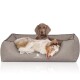 Ein gemütliches Hundebett in neutralem Grauton mit einem Logo, das "KNUFFELWUFF" liest, mit zwei Hunden, die bequem liegen.