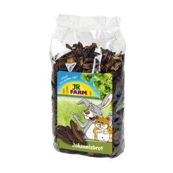 Eine durchsichtige Plastiktüte gefüllt mit getrockneten Johannisbrot-Schoten, mit einem bunten Etikett, das einen Cartoon-Hasen und einen Hamster zeigt, beschriftet mit "JR FARM Johannisbrot."