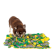 Ein brauner Hund schnüffelt an einer bunten Schnüffelmatte aus grünen, gelben und grauen Stoffstücken, die für interaktives Spielen entworfen wurde.