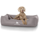 Ein hellgraues Hundebett mit dem Logo 'KNUFFELWUFF', das prominent angezeigt wird, mit einem entspannten Hund, der bequem darauf liegt.