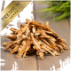 Ein Haufen getrockneter Fischleckereien für Haustiere, beschriftet mit "PREMIUM" in einem goldenen Banner, auf einer Holzoberfläche mit grünem Gras im Hintergrund.