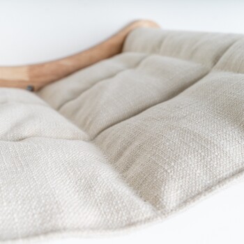 Nahaufnahme eines weichen, beigen Haustierbettkissens mit gepolstertem Stoff und einem Holzrahmen, ideal für den Komfort von Haustieren.