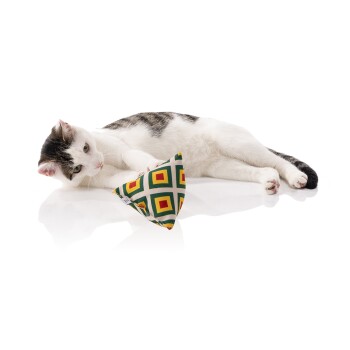 Eine verspielte weiß-graue Katze liegt auf einer reflektierenden Oberfläche und spielt mit einem bunten dreieckigen Spielzeug mit geometrischem Muster.