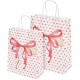 Zwei dekorative Geschenktüten mit roten Bändern und Herzmustern in verschiedenen Rosa- und Rottönen, ideal für haustierbezogene Geschenke.