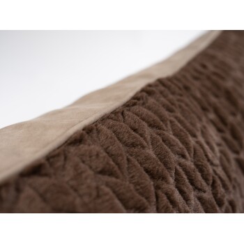 Nahaufnahme eines plüschigen braunen Haustierbettes mit einer gesteppten Textur und einem glatten beigen Rand, das seine weichen Materialien zeigt.
