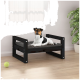 Ein schwarzes Hundebett aus Holz mit einem grauen Kissen hält einen entspannten schwarz-weißen Hund, mit einem grünen Tennisball auf dem Boden in der Nähe.