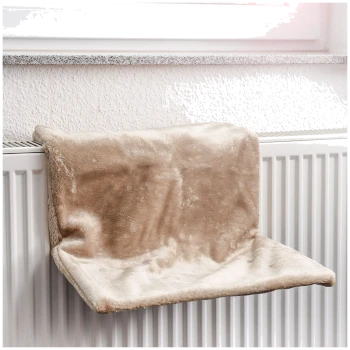 Ein weiches, beiges Haustierregal, das auf einem weißen Heizkörper ruht, entworfen für Katzen, um bequem am Fenster zu entspannen.