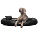 Ein grauer Weimaraner-Hund liegt auf einem plüschigen schwarzen Haustierbett mit einem kleinen Kissen, mit einem Lederetikett, auf dem "tierland" steht.