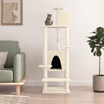 Ein hoher Katzenbaum in Creme mit Plattformen und einem gemütlichen Versteck, gekrönt von einer getigerten Katze, neben einem grünen Sofa und einer Topfpflanze.