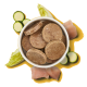Eine Schüssel mit runden Haustierfutter-Patties, umgeben von Stücken rohem Fleisch, Kürbis und Brokkoli auf grünem Hintergrund.