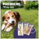 Image d'une zone herbeuse présentant des friandises à mâcher pour chiens de la marque "Premiere I ❤️ mon chien," incluant un os emballé et diverses friandises à mâcher.
