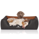 Ein gemütliches schwarz-braunes Hundebett mit einem verspielten Australian Shepherd, der sich entspannt, mit dem Logo "KNUFFELWUFF."
