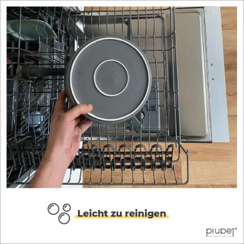 Eine Person hält eine graue Futterschüssel für Haustiere über dem offenen Regal eines Geschirrspülers, mit dem Text "Leicht zu reinigen" am unteren Rand.