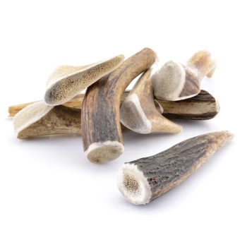 Geweih S ca. 50-80g Ein Haufen natürlicher Hundekauhorn in verschiedenen Formen und Größen, der ihre strukturierten Oberflächen und Enden zeigt.