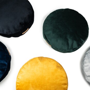 Eine Sammlung von fünf runden, plüschigen Haustierkissen in verschiedenen Farben: schwarz, dunkelgrün, marineblau, gelb und silber, auf einem weißen Hintergrund angeordnet.