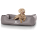 Ein hellgraßiges Hundebett mit einem gesteppten Design, das das Logo 'KNUFFELWUFF' zeigt, und ein Hund, der bequem darauf ruht.