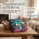 Ein glücklicher Hund mit offenem Mund wird vor einem bunten Hintergrund gezeigt, umgeben von leuchtenden Kundenbewertungen über die Saugfähigkeit und Qualität eines Handtuchs.