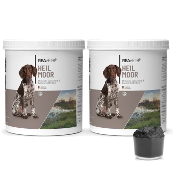 Zwei Behälter mit REAVET Heil Moor für Hunde, mit der Aufschrift "Optimale Verdauung & Kotbeschaffenheit", neben einer kleinen Schüssel mit schwarzem Pulver.