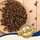 Getrocknete Insektenlarven auf einem Holzbrett mit einem goldenen Siegel mit der Aufschrift „Bewährte Qualität, 15 Jahre, Best Quality“ auf einer Holzoberfläche.