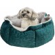 Ein kleiner, flauschiger Hund mit grau-weißer Fellfarbe sitzt bequem in einem tealfarbenen Hundebett mit einem weichen grauen Innenraum.