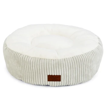 Rundes Haustierbett mit einem plüschigen weißen Zentrum und weichen grauen Rippseiten, mit einem kleinen braunen Etikett, das 'Designed by Cotte' liest.