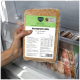 Hand hält verpacktes tiefgefrorenes Hundefutter mit der Aufschrift „Barfer's complete Komplett-Mix Huhn & Lachs 500 g“ im Gefrierschrank.