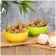 Zwei Schalen gefüllt mit Hundesnacks in Form von Knochen, eine gelbe und eine grüne, auf einer Juteschicht mit zwei Seilspielzeugen in der Nähe.