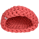 Un lit pour animaux de compagnie confortable de couleur corail avec un design tressé, présentant une entrée arrondie et un intérieur doux.