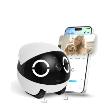 Eine robotische Haustierkamera mit einem weißen und schwarzen Design, mit einem Objektiv und ausdrucksvollen Augen, neben einem Smartphone, das einen Videoanruf mit einem Hund zeigt.