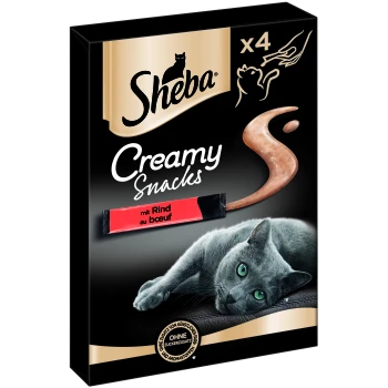 Emballage de Sheba Creamy Snacks avec un chat gris sur une surface noire, présentant un paquet rouge étiqueté "mit Rind au bœuf" et sans sucre ajouté.