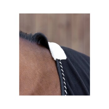Nahaufnahme des Halses eines Pferdes, das eine schwarze Fleece-Decke mit einem weißen Kragen und dekorativer Naht trägt.