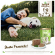 Eine Person entspannt sich auf dem Gras mit einem glücklichen weißen Hund, einer Dose Hundefutter und einem Teller mit Essen, mit dem Text "Beste Freunde!" darunter.