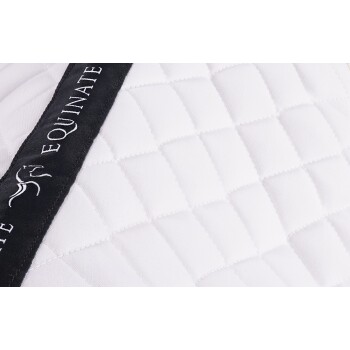 Nahaufnahme einer weißen, gesteppten Pferdedecke mit einem schwarzen Riemen, der den Markennamen "EQUINATE" in weißem Text trägt.