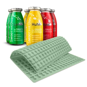 Drei bunte Flaschen mit der Aufschrift "SmoothieDog" in grün (Lamm), gelb (Huhn) und rot (Rind) mit einer gelben Silikonmatte für Haustiersnacks.