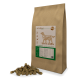 Braune Papiertüte mit Hundefutter, beschriftet mit "Lamm & Reis", mit einer Silhouette eines Hundes, die Kibble-Stücke auf dem Boden zeigt.