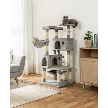 Zwei graue Katzen entspannen auf einem hohen, grauen Katzenbaum mit mehreren Ebenen, Kratzpfosten und einer gemütlichen Hängematte, in einem hellen Wohnzimmer.
