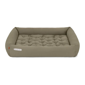 Ein plüschiges, rechteckiges Hundebett in einem weichen taupe Farbton mit gestepptem Design und erhöhten Kanten, mit einem "Doctor Bark" Logo.