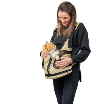 Eine Frau in einem schwarzen Pullover hält eine beigen Haustiertrage, aus der eine flauschige orangefarbene Katze herausblickt, und zeigt ein stilvolles und funktionales Design.