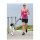 Eine Frau in einem rosa Tanktop und schwarzen Shorts joggt auf einem Weg mit einem schwarz-weißen Hund an der Leine, vor einer malerischen Ozeankulisse.