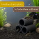 Gestapelte schwarze Aquariumröhren mit kleinen Welsen; deutscher Text 'Ideal als Laichplatz — für Fische, Welse und Krebse'.