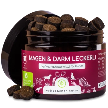 Schwarze Hundeleckerlis in einem Glas mit der Aufschrift "Magen & Darm Leckerli" für Hunde, mit Nährwertangaben und der Marke "wolfsbacher natur."